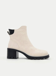 Beige ankle boots with a block heel and black detail.
