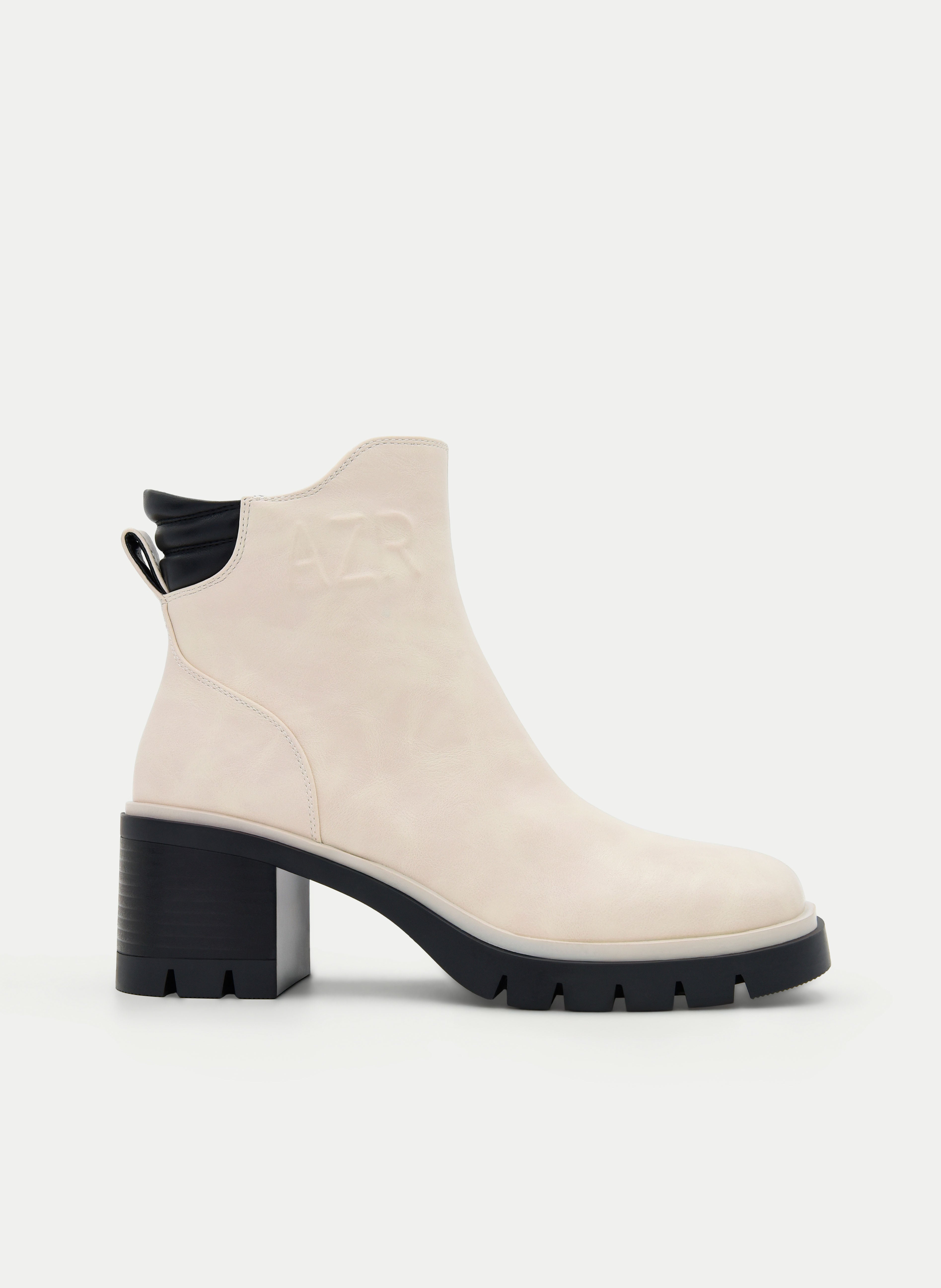 Beige ankle boots with a block heel and black detail.