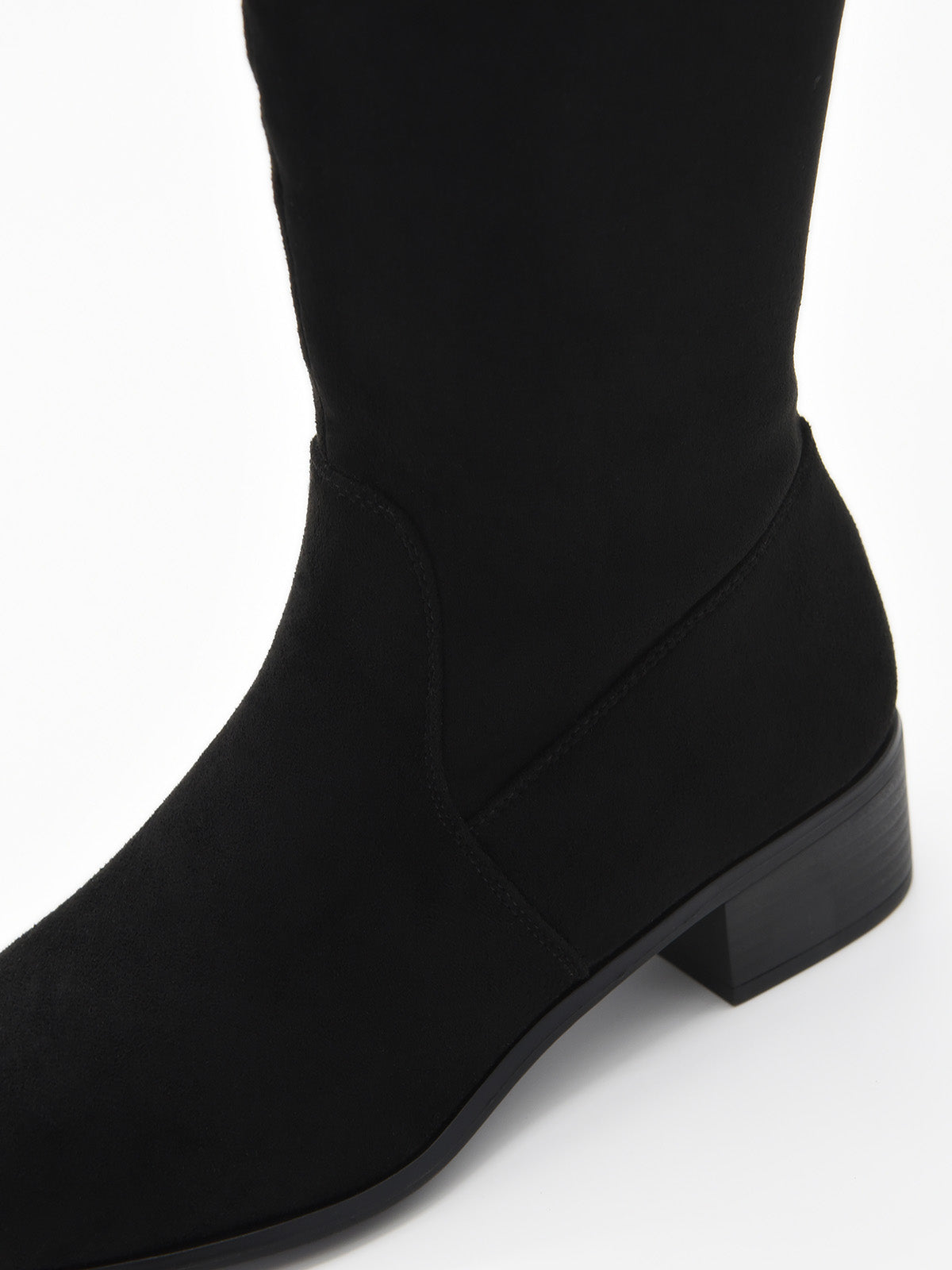 Bota alta de mujer en color negro, de efecto ante con tacón bajo cuadrado y punta ligeramente fina.