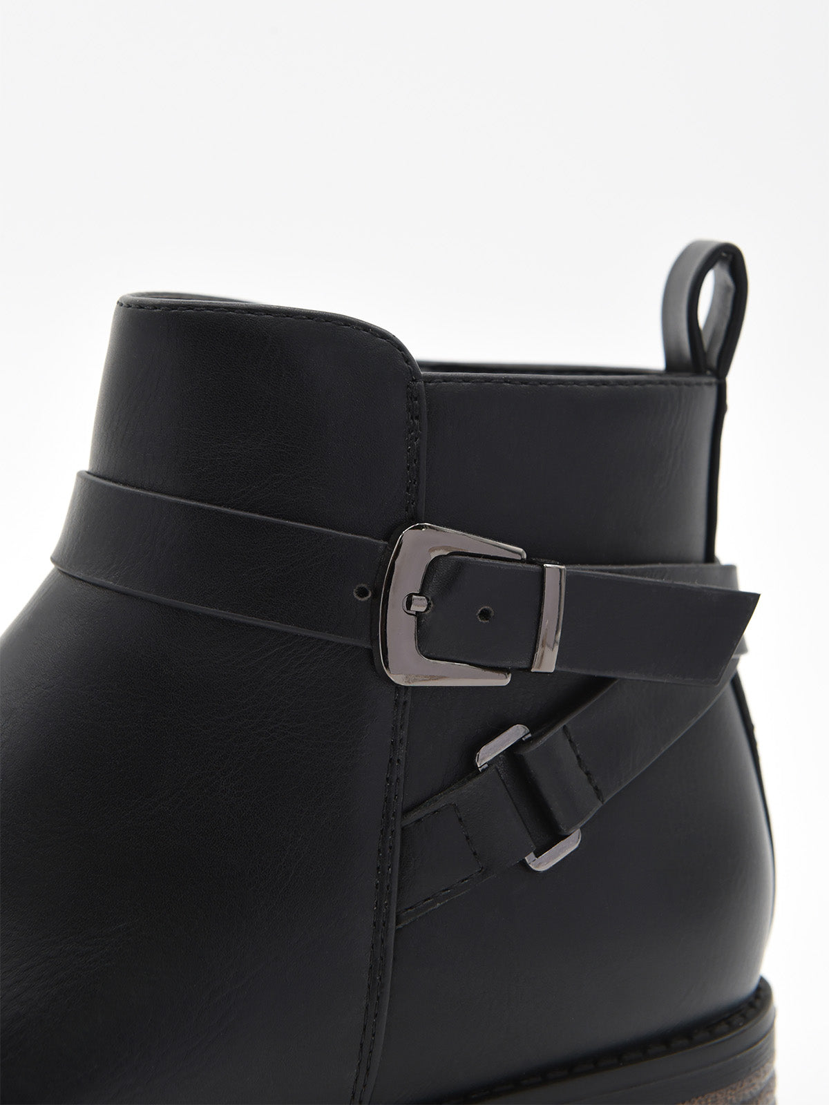 Botín de mujer en material sintético negro efecto piel, con hebilla lateral metálica y tacón bajo ancho con detalle de madera.